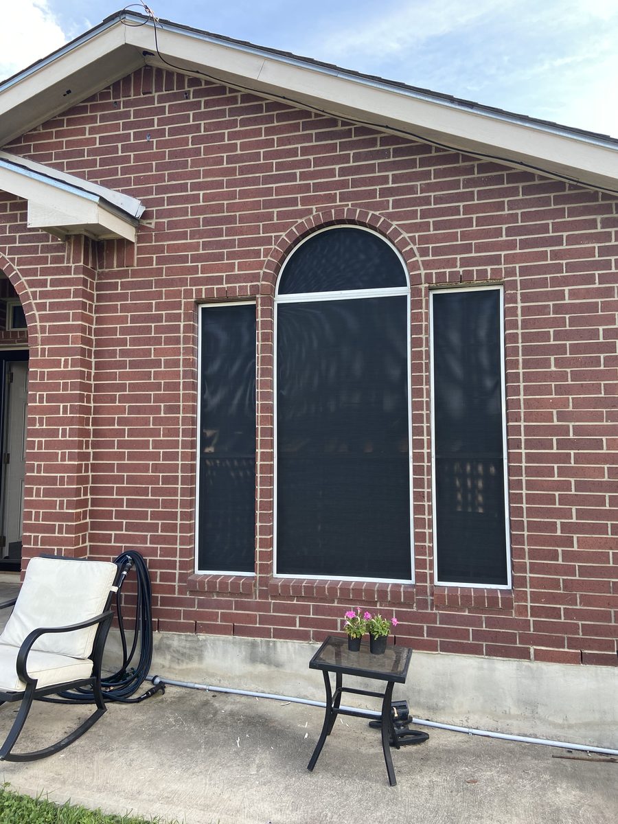 Arched top window solar screen on brick home