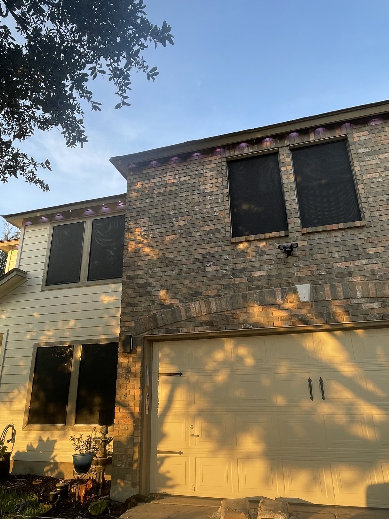 Beige two-story home with solar screens at golden hour